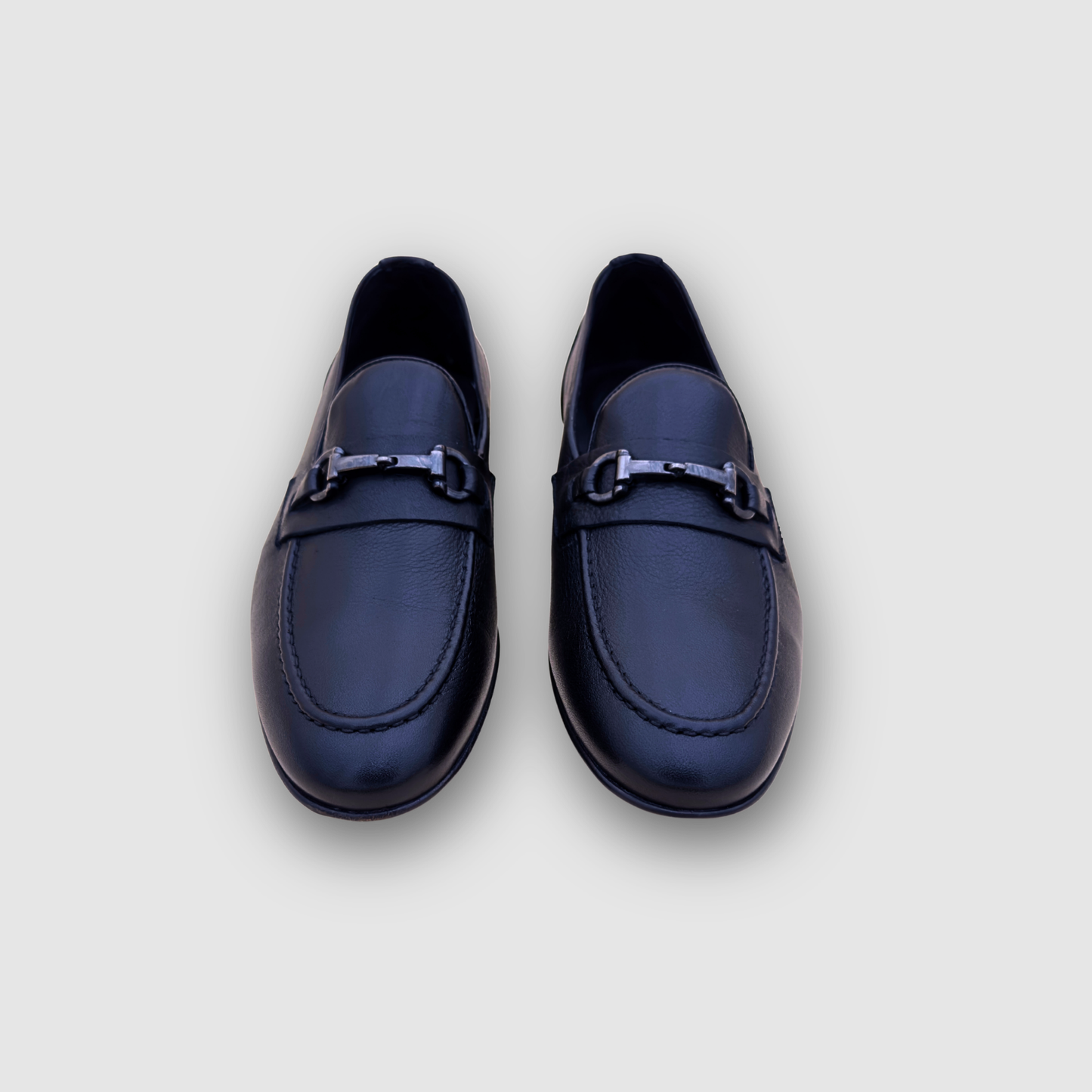 Mocassins homme cuir noir vue face, paire élégante avec mors métallique style luxe