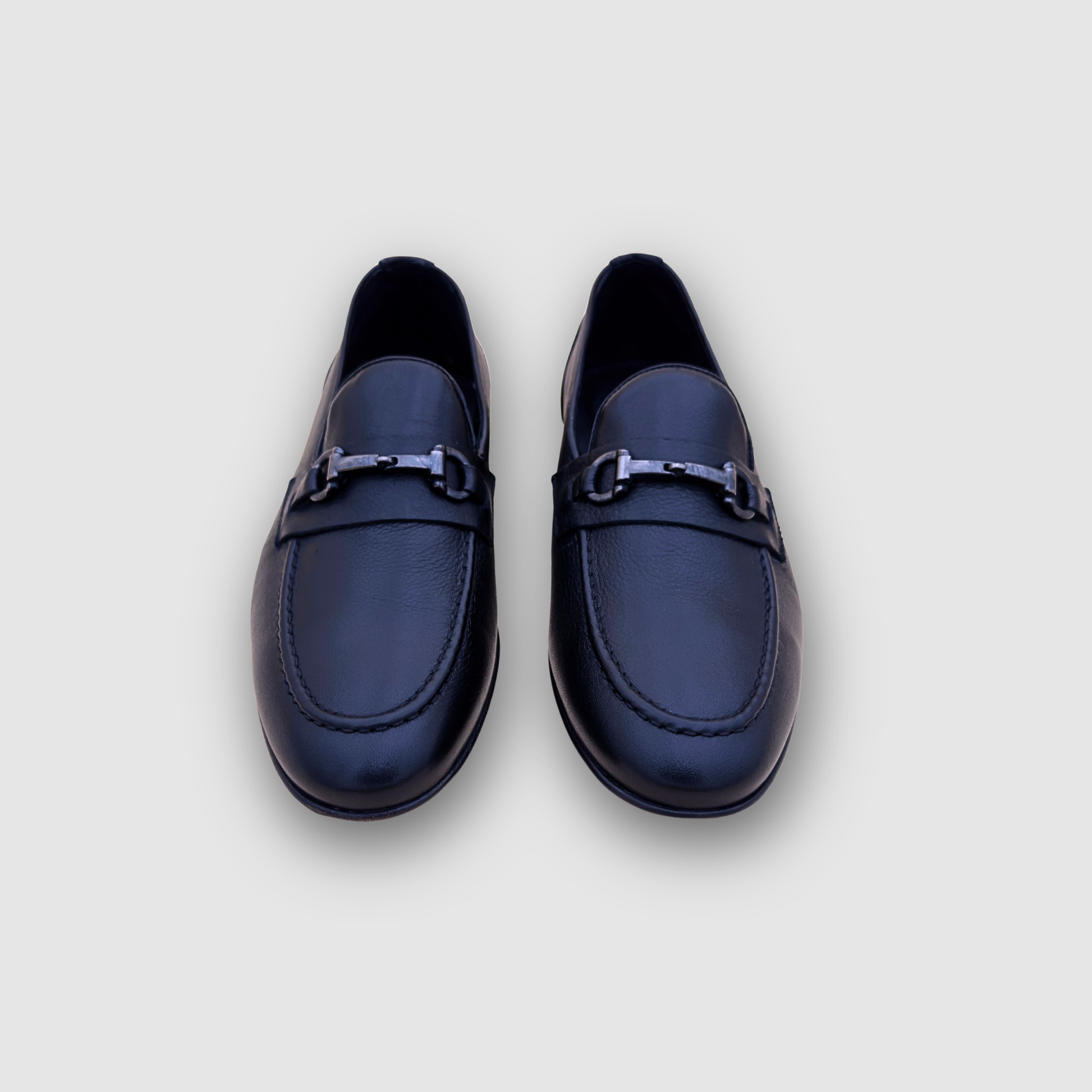 Mocassins homme cuir noir vue face, paire élégante avec mors métallique style luxe